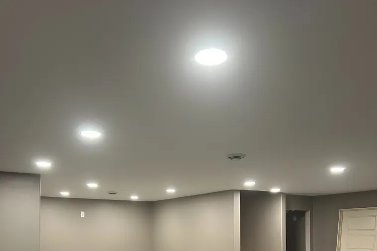 Finished basement with rows of recessed LED lights across the ceiling