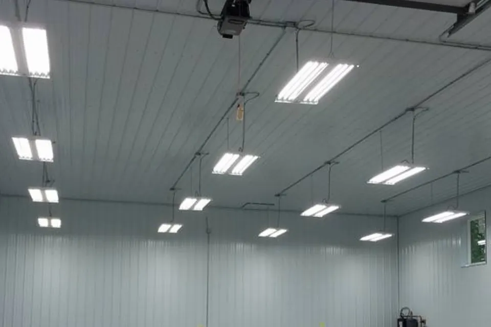 Large steel shop lit by rows of hanging LED strip fixtures